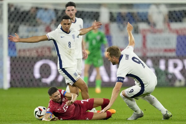 Filip Mladenovic của Serbia ngã sau khi va chạm với Trent Alexander-Arnold của Anh trong trận đấu bảng C giữa Serbia và Anh tại giải bóng đá Euro 2024 ở Gelsenkirchen, Đức, Chủ nhật, ngày 16 tháng 6 năm 2024. (Ảnh AP / Andreea Alexandru)