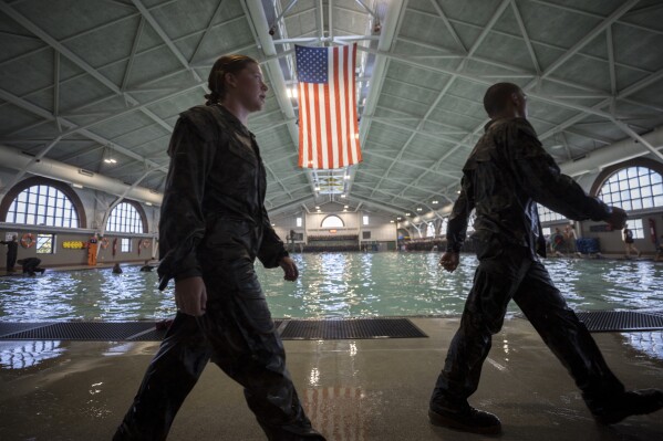 A female U.S. Marine Corps recruit, left, and a male recruit march back into formation at the Marine Corps Recruit Depot pool during integrated swim training, Wednesday, June 28, 2023, in Parris Island, S.C. (AP Photo/Stephen B. Morton)