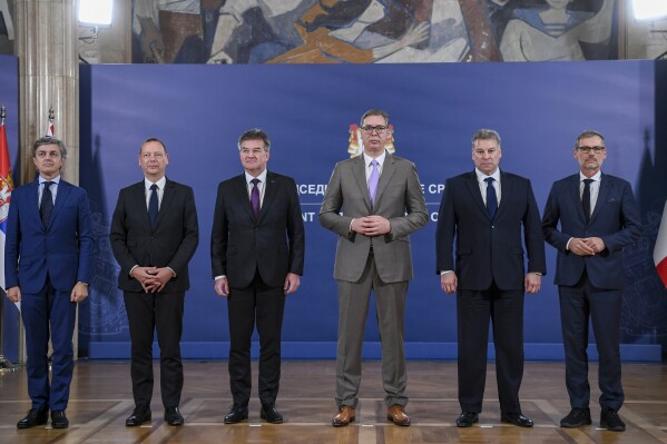 In this photo provided by the Serbian Presidential Press Service, Serbian President Aleksandar Vucic, third right, poses with Italian diplomat Alessandro Cattaneo, left, French President's Advisor Emmanuel Bonne, second left, European Union envoy Miroslav Lajcak, third left, US Deputy Assistant Secretary Gabriel Escobar , second right, and German Chancellor's Advisor Jens Plettner, right, in Belgrade, Serbia, Saturday, Oct. 21, 2023. The envoys of the European Union and the United States urged on Saturday Kosovo and Serbia to resume dialogue as the only way to de-escalate the soaring tension between the two nations. This is the first such visit since Sept. 24 when around 30 Serb gunmen crossed into northern Kosovo, killing a police officer and setting up barricades, before launching an hours-long gun battle with Kosovo police. (Serbian Presidential Press Service via AP)