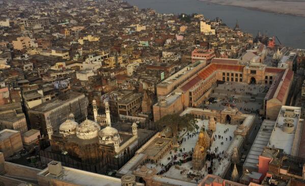 An Aerial view shows Gyanvapi mosque, left, and Kashiviswanath temple on the banks of the river Ganges in Varanasi, India, Dec. 12, 2021. A group of Hindus petitioned a local court seeking access to pray inside the mosque compound, saying they believe the Gyanvapi mosque in Varanasi, one of Hinduism’s holiest cities, was built on top of the ruins of a medieval-era temple and that the complex still houses Hindu idols and motifs, a claim that has been contested by the mosque authorities. (AP Photo/Rajesh Kumar Singh)