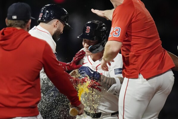 Boston Red Sox's Tyler O'Neill, center, celebrates after his walkoff RBI single with teammates during the ninth inning of a baseball game against the Chicago Cubs, Sunday, April 28, 2024, in Boston. (AP Photo/Michael Dwyer)