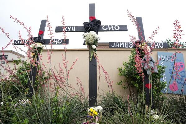 Crosses with the names, Cindy Cho, Kyu Cho and James Cho, who were victimes of a mass shooting stand at a makeshift memorial by the mall where several people were killed, Wednesday, May 10, 2023, in Allen, Texas. (AP Photo/Tony Gutierrez)