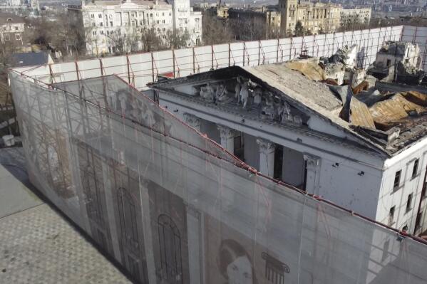 This Dec. 2, 2022 image from video shows fencing surrounding the Drama Theater in Mariupol, Ukraine. Months after hundreds died in Russian airstrikes on the theater, the fencing is etched with Russian and Ukrainian literary figures as well as an outline of the theater's previous life, before Russian occupation. (AP Photo)
