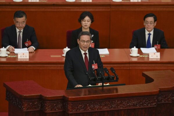 Chinese Premier Li Qiang, center, speaks during the opening session of the National People's Congress (NPC) at the Great Hall of the People in Beijing, China, Tuesday, March 5, 2024. (AP Photo/Ng Han Guan)