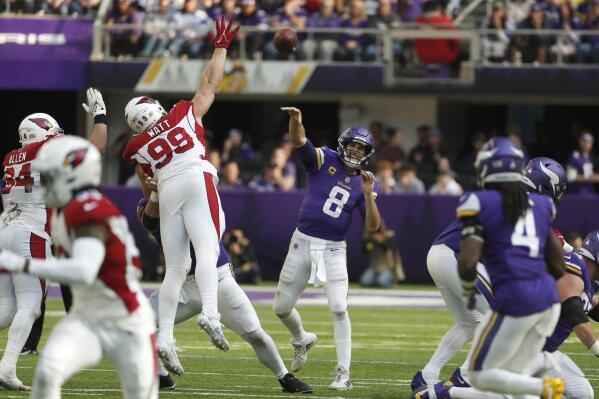Minnesota Vikings quarterback Kirk Cousins (8) throws a pass over Arizona Cardinals defensive end J.J. Watt (99) during the second half of an NFL football game, Sunday, Oct. 30, 2022, in Minneapolis. (AP Photo/Bruce Kluckhohn)