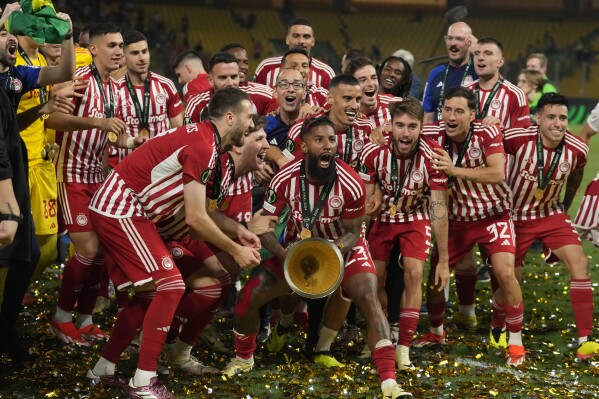 Olympiacos' Rodinei celebrates with the trophy at the end of the Conference League final soccer match between Olympiacos FC and ACF Fiorentina at OPAP Arena in Athens, Greece, Thursday, May 30, 2024. Olympiacos won 1-0. (AP Photo/Thanassis Stavrakis)