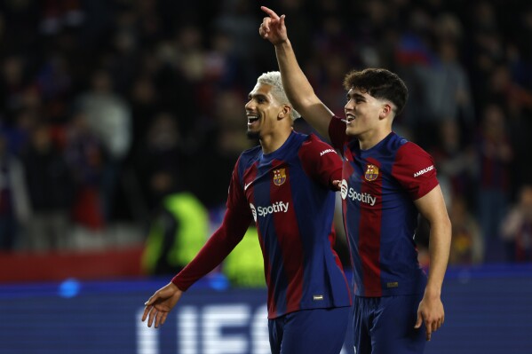 Barcelona's Pau Cubarsi, right, and Barcelona's Ronald Araujo celebrate after the Champions League, round of 16, second leg soccer match between FC Barcelona and SSC Napoli at the Olympic Stadium in Barcelona, Spain, Tuesday, March 12, 2024. (AP Photo/Joan Monfort)