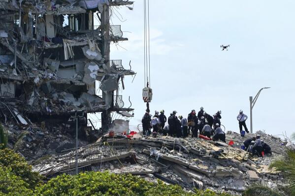 Rescue workers search in the rubble for survivors at the Champlain Towers South condominium, Saturday, June 26, 2021, in the Surfside area of Miami. The building partially collapsed on Thursday. (AP Photo/Lynne Sladky)