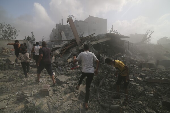 Palestinians look for survivers in buildings destroyed in the Israeli bombardment of the Gaza Strip in Rafah, Sunday, Oct. 22, 2023. (AP Photo/Hatem Ali)