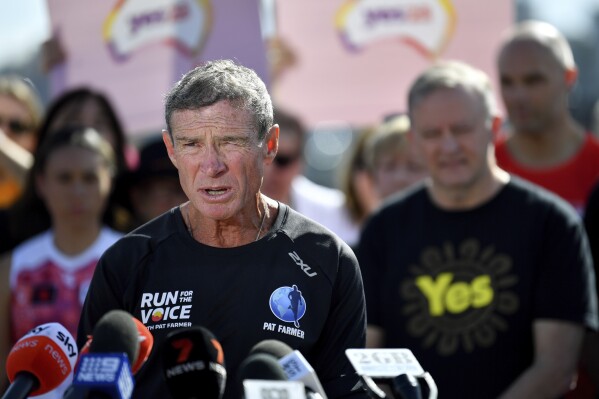Pat Farmer, left, as speaks on his arrival at the Sydney Opera House on his Run for the Voice campaign, as Australian Prime Minister Anthony Albanese, right, listens in Sydney, Aug. 22, 2023. Ultramarathon runner Farmer ended a 14,400-kilometer (8,950-mile) run at the central Australian sandstone landmark Uluru on Wednesday, Oct. 11, 2023, after a seven-month journey to raise public support for the creation of an Indigenous advocacy body in the constitution. (Bianca De Marchi/AAP Image via AP)