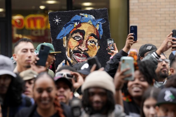 FILE - An image of the late rapper and actor Tupac Shakur appears among fans during a ceremony honoring Shakur with a star on the Hollywood Walk of Fame on Wednesday, June 7, 2023, in Los Angeles. The unsolved killing of Shakur has taken a major turn. Duane “Keffe D” Davis was arrested Friday morning, although the exact charge or charges were not immediately clear, according to two officials with first-hand knowledge of the arrest. The renewed activity comes nearly 30 years after Shakur was gunned down on Sept. 7, 1996. (AP Photo/Chris Pizzello, File)