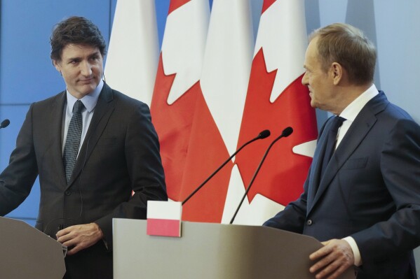 Poland's Prime Minister Donald Tusk, right, and Canada's Prime Minister Justin Trudeau, left, address the media following their talks, on European security and support for Poland's neighbor, Ukraine, in its struggle against Russia's aggression, in Warsaw, Poland, on Monday, Feb. 26, 2024. Trudeau is on his way back from a visit to Kyiv. (AP Photo/Czarek Sokolowski)