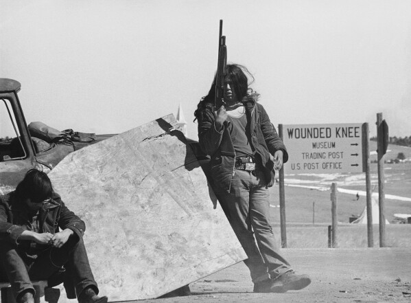 AIM guards continue to man roadblocks on roads into Wounded Knee, South Dakota, March 19, 1973, as talks between government and American Indian Movement leaders continue. AIM stated that they wanted to talk to the president or his emissary according to the Sioux Treaty of 1868. (AP Photo/Fred Jewell)