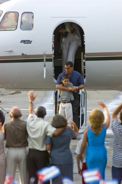 Elian Gonzalez arrives to Havana's Jose Marti international airport carried by his father Juan Miguel Gonzalez, Wednesday, June 28, 2000. (AP Photo/Ricardo Mazalan)