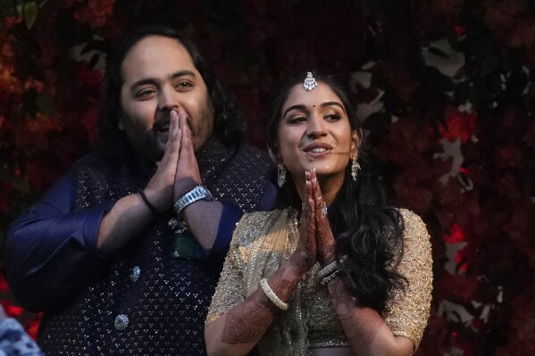 Anant Ambani, left, son of Chairman of Reliance Industries Limited Mukesh Ambani and his fiancee Radhika Merchant greet media persons during their engagement ceremony in Mumbai, India, Thursday, Jan. 19, 2023. (AP Photo/Rajanish Kakade)