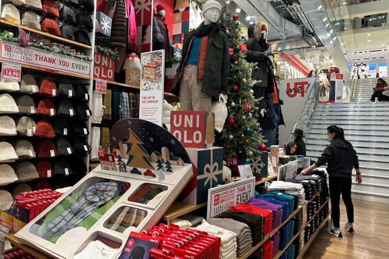 Shoppers looks at items displayed at the Uniqlo stores in New York on Sunday, Nov. 19, 2023. Retailers are kicking off the unofficial start of the holiday shopping season on Friday with a bevy of discounts and other enticements. (AP Photo/Anne D'Innocenzio)