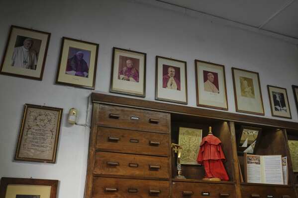 Portraits of late Popes hang at the Gammarelli ecclesiastic clothes tailor shop in Rome, Wednesday, April 30, 2025. (AP Photo/Francisco Seco)