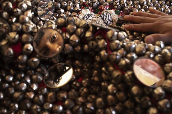 Daniel Davila is reflected in a mirror as he prepares his costume at his home in San Agustin, Mexico, Monday, Oct. 30, 2023. Mexicans in the Oaxacan town celebrate the traditional Muerteada, a theatrical recreation that is performed through the night of November 1 until the early morning of the following day, with dances and music parading through the streets, while telling the story of how a deceased person is resurrected with the help of a priest, a doctor and a spiritist. (AP Photo/Maria Alferez)