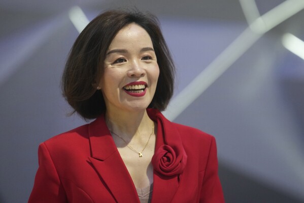 Vu Dang Yen Hang, chief executive officer of VinFast Thailand, smiles in front of its electric vehicle "VF7" during the 45th Bangkok Motor Show in Nonthaburi, Thailand, Tuesday, March 26, 2024. (AP Photo/Sakchai Lalit)
