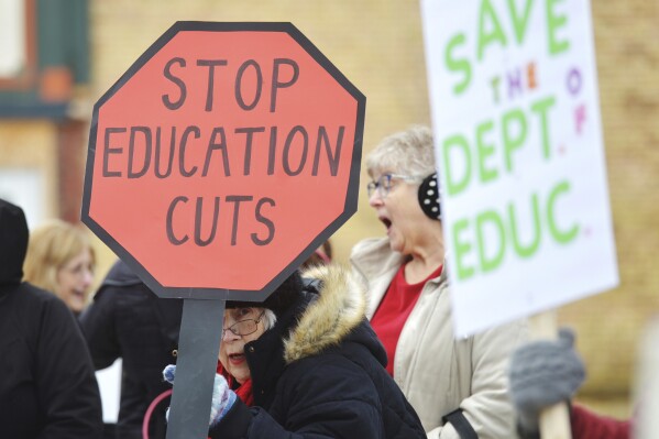 Dozens of people gather in downtown Niles, Mich., Thursday, March 20, 2025, to protest recent government cuts in the Department of Education. (Don Campbell/The Herald-Palladium via AP)