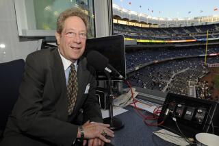 FILE - In this Sept. 25, 2009, file photo, New York Yankees broadcaster John Sterling sits in the booth before the Yankees' baseball game against the Boston Red Sox at Yankee Stadium in New York. Sterling was helped out of his flooding car by Spanish radio play-by-play man Rickie Ricardo on Wednesday night, Sept. 1, 2021, after Sterling got stuck trying to drive home after a game. Sterling and Ricardo both called New York's game at the Los Angeles Angels from Yankee Stadium because the radio crews have not resumed traveling with the team as part of COVID-19 protocols. (AP Photo/Bill Kostroun, File)