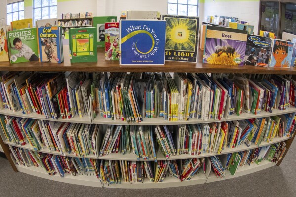 Books sit on shelves in an elementary school library in suburban Atlanta on Friday, 18, 2023. Although not new, book challenges have surged in public schools since 2020, part of a broader backlash to what kids read and discuss in school. (AP Photo/Hakim Wright Sr.)