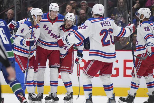 New York Rangers' Braden Schneider, Niko Mikkola, Artemi Panarin, Jimmy Vesey and Vincent Trocheck, from left, celebrate Mikkola's goal against the Vancouver Canucks during the first period of an NHL hockey game Wednesday, Feb. 15, 2023, in Vancouver, British Columbia. (Darryl Dyck/The Canadian Press via AP)