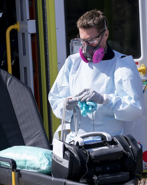 A paramedic cleans ambulance equipment after transporting a patient to the Verdun Hospital in Montreal, on Monday, April 6, 2020. Prime Minister Justin Trudeau says he’s confident Canada will still be able to import N95 protective masks form the U.S. despite an export ban and says he will talk to U.S. President Donald Trump in the coming days. (Paul Chiasson/The Canadian Press via AP)