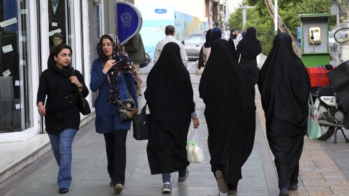 FILE - Iranian women make their way along a sidewalk in downtown Tehran, Iran, Tuesday, April 26, 2016. Iranian police have announced a new campaign to force women to wear the Islamic headscarf. Morality police returned to the streets on Sunday, 10 months after the death of a woman in their custody sparked nationwide protests. (AP Photo/Vahid Salemi, File)