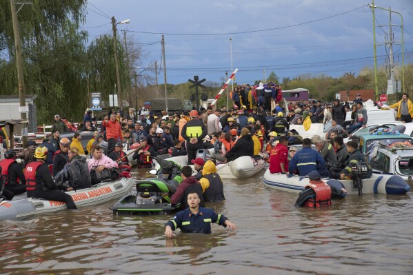 Rescue workers evacuate residents following heavy rains in Campana, Argentina, Saturday, May 17, 2025. (AP Photo/Rodrigo Abd)