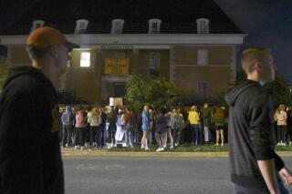 FILE - Protestors, opposing fraternity hazing, sexual assault and demanding accountability, chant outside the Phi Gamma Delta fraternity on Wednesday, Oct. 20, 2021, in Columbia, Mo. The parents of a University of Missouri student from Minnesota are suing the Phi Gamma Delta fraternity after their son suffered serious brain injuries during a pledge party. The lawsuit alleges pledges at the Phi Gamma Delta fraternity were expected to drink an entire bottle of alcohol as part of a fraternity tradition. Authorities say Daniel Santulli's blood alcohol content was more than six times the legal limit for driving on Oct. 20, 2021, when he was found unresponsive in a car parked at University Hospital. (Nicole Gutierrez/Missourian via AP, File)