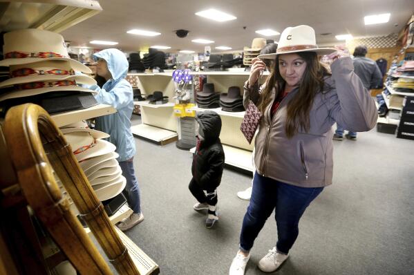 Irene Schaefer, of Johnson Creek, Wis., shops for hats at Longhorn Saddlery in Dubuque, Iowa, on Friday, Dec. 30, 2022. On Wednesday, the Commerce Department releases U.S. retail sales data for December. (Jessica Reilly/Telegraph Herald via AP)