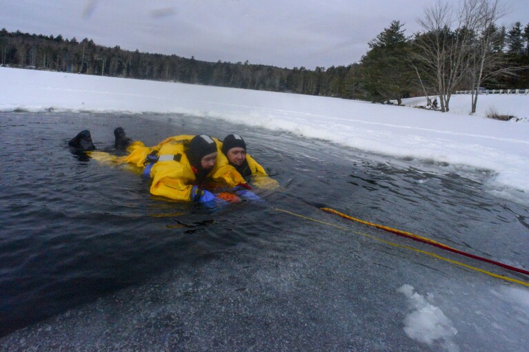 Members of the Bellows Falls, Vt., Fire Department practice cold water rescue training at Minard's Pond in Bellows Falls, Vt., on Saturday, Jan. 20, 2024. (Kristopher Radder/The Brattleboro Reformer via AP)