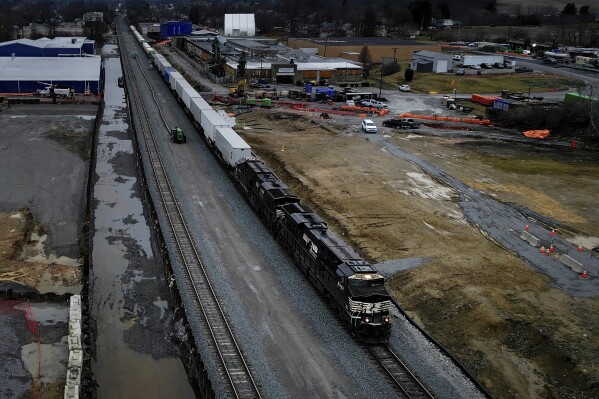 In this frame grab taken from video, a Norfolk Southern train moves down the track in East Palestine, Ohio, on Monday, Jan. 29, 2024, as cleanup continues. Daily life largely returned to normal for residents of East Palestine, Ohio, months after a Norfolk Southern train derailed and spilled a cocktail of hazardous chemicals that caught fire a year ago, but the worries and fears are always there. (AP Photo/Carolyn Kaster)