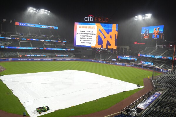 Eine Plane deckt das Innenfeld ab, nachdem ein geplantes Baseballspiel zwischen den Detroit Tigers und den New York Mets am Dienstag, dem 2. April 2024, in New York wegen schlechten Wetters verschoben wurde.  (AP Photo/Frank Franklin II)