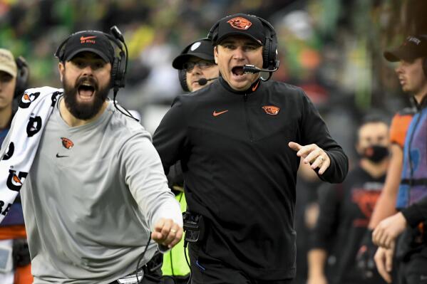 Oregon State head coach Jonathan Smith, right, and tight ends coach Brian Wozniak yell at players that they are going for a two-point conversing during the fourth quarter of an NCAA college football game against Oregon, Saturday, Nov. 27, 2021, in Eugene, Ore. (AP Photo/Andy Nelson)