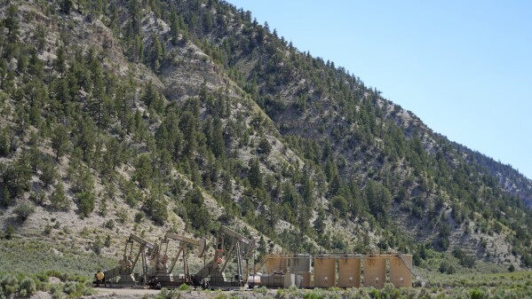 Pumpjacks dip their heads to extract oil in a basin south of Duchesne, Utah on Thursday, July 13, 2023. Uinta Basin Railway, one of the United States’ biggest rail investments in more than a century, could be an 88-mile line in Utah that would run through tribal lands and national forest to move oil and gas to the national rail network. Critics question investing billions in oil and gas infrastructure as the country seeks to use less of the fossil fuels that worsen climate change. (AP Photo/Rick Bowmer)