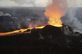 
              FILE - In this Saturday, July 14, 2018 photo provided by the U.S. Geological Survey, lava from Kilauea volcano erupts in the Leilani Estates neighborhood near Pahoa, Hawaii. On Thursday, Oct. 25, 2018, government scientists updated 18 U.S. volcanoes as a “very high threat” because of what’s been happening inside them and how close they are to people. (U.S. Geological Survey via AP)
            