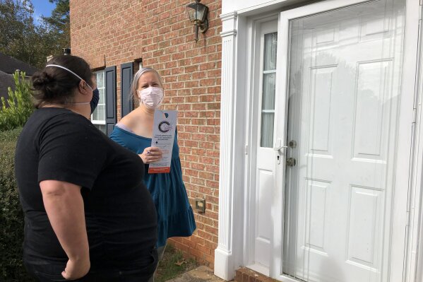 Sarah Meng, left, and Christin Clatterbuck wait for someone to answer the door at a home in Lilburn, Ga., Friday, Nov. 6, 2020, where they had information that there was a problem with a voter’s absentee ballot. (AP Photo/Sudhin Thanawala)