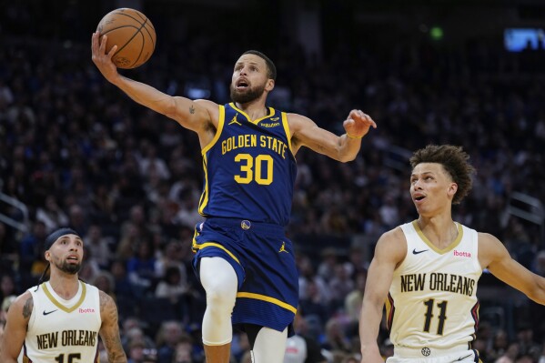 Golden State Warriors guard Stephen Curry (30) shoots between New Orleans Pelicans guards Jose Alvarado, left, and Dyson Daniels during the first half of an NBA basketball game Friday, April 12, 2024, in San Francisco. (AP Photo/Godofredo A. Vásquez)