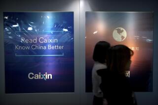 FILE - In this Jan. 18, 2018, file photo, staffers walk past a billboard reading "Read Caixin - Know China Better" at the Caixin Media offices in Beijing. China has removed Caixin Media, one of the country’s most liberal business news sites, from a list of official news outlets that can be republished by other internet news providers in the Communist Party's latest move to control the flow of information.(AP Photo/Mark Schiefelbein, File)