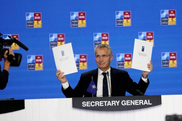 NATO Secretary General Jens Stoltenberg holds up a letter of commitment to innovation at a NATO summit in Madrid, Spain on Thursday, June 30, 2022. North Atlantic Treaty Organization heads of state will meet for the final day of a NATO summit in Madrid on Thursday. (AP Photo/Paul White)
