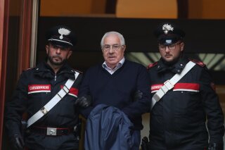 
              CORRECTS FIRST NAME TO SETTIMO, NOT SETTIMINO - Settimo Mineo, center, who allegedly took over as the Palermo head of Cosa Nostra, is escorted by Italian Carabinieri police after an anti Mafia operation which led the arrest of 46 people including the presumed regional boss, in Palermo, Sicily, Italy, Tuesday, Dec. 4, 2018.  Italian police say they have dismantled the rebuilt upper echelons of the Sicilian Mafia. (Igor Petyx/ANSA via AP)
            