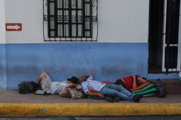 Migrants sleep on a sidewalk in Tapachula, Chiapas state, Mexico, Saturday, June 8, 2019. President Donald Trump has put on hold his plan to begin imposing tariffs on Mexico on Monday, saying the U...
