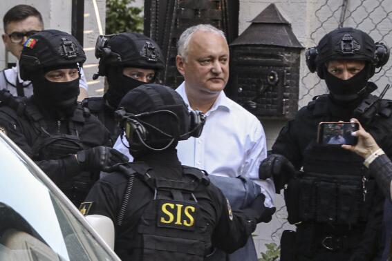 FILE - Members of Moldova's Information and Security service (SIS) escort former Moldovan President Igor Dodon to a van after he was detained at his house in Chisinau, Moldova, May 24, 2022. A court in Moldova has placed former President Igor Dodon under 30-day house arrest. He faces an investigation into suspected treason, corruption, illicit enrichment and illegal party financing. The ruling came Thursday, May 26. (AP Photo/Aurel Obreja, file)