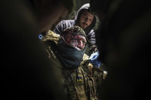 Ukrainian military doctors treat an injured comrade at a hospital in the Donetsk region, Ukraine, Monday, Jan. 9, 2023. (AP Photo/Evgeniy Maloletka)