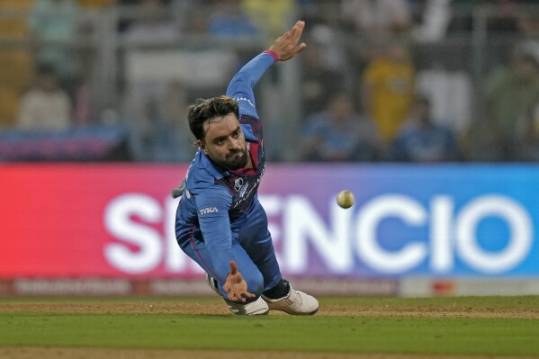 FILE - Afghanistan's Rashid Khan dives to field the ball during the ICC Men's Cricket World Cup match between Australia and Afghanistan in Mumbai, India, on Nov. 7, 2023. Cricket Australia has postponed a three-match men’s Twenty20 international series against Afghanistan scheduled for August due to concerns over deteriorating human rights for women and girls in the Taliban-controlled country. (AP Photo/Rajanish Kakade, File)