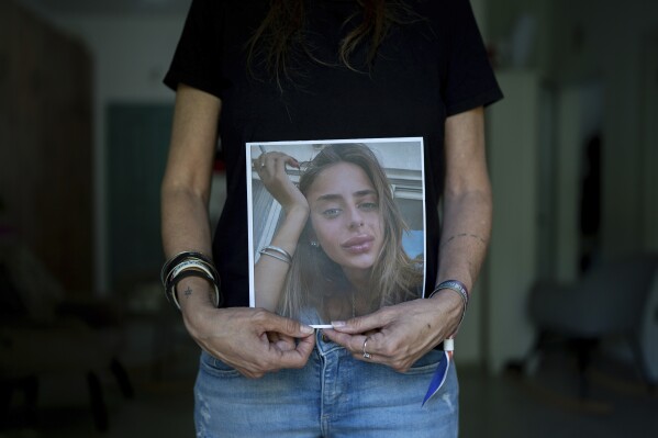 Keren Scharf Schem holds up a portrait of her daughter, 21-year-old Mia Schem, in the family house in Mazor, central Israel, Wednesday, Oct. 25, 2023. Schem, an Israeli and French citizen, was abducted by Hamas militants from the Nova Music Festival near Kibbutz Re'im, Israel, and was taken into Gaza during the group's unprecedented attack on Israel on Oct. 7 that resulted in the killing of 1,400 people and abduction of over 220. (AP Photo/Ohad Zwigenberg)