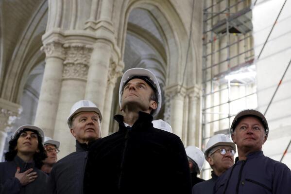 French President Emmanuel Macron, center, French Culture Minister Rima Abdul Malak, left, French Army General Jean-Louis Georgelin, second left, Chief architect Philippe Villeneuve,, right, visit the restoration site at the Notre-Dame de Paris Cathedral, which was damaged in a devastating fire four years ago, Friday, April 14, 2023 in Paris. (Sarah Meyssonnier/Pool via AP)