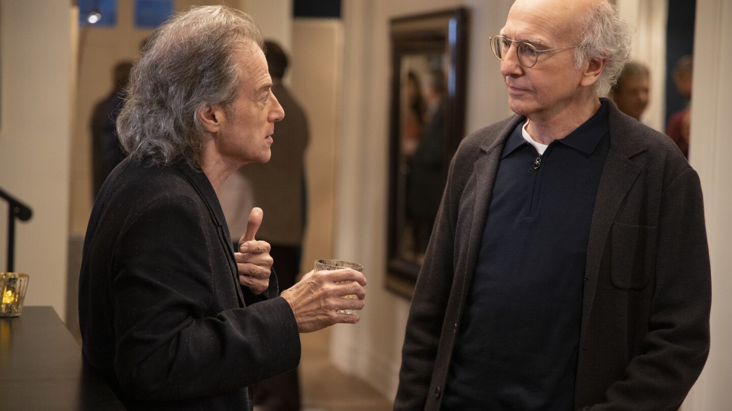 This image released by HBO shows Richard Lewis, left, with Larry David in a scene from Season 10 of "Curb Your Enthusiasm." Lewis, an acclaimed comedian known for exploring his neuroses in frantic, stream-of-consciousness diatribes while dressed in all-black, leading to his nickname “The Prince of Pain,” has died. He was 76. He died at his home in Los Angeles on Tuesday night after suffering a heart attack, according to his publicist Jeff Abraham. (John P. Johnson/HBO via AP)